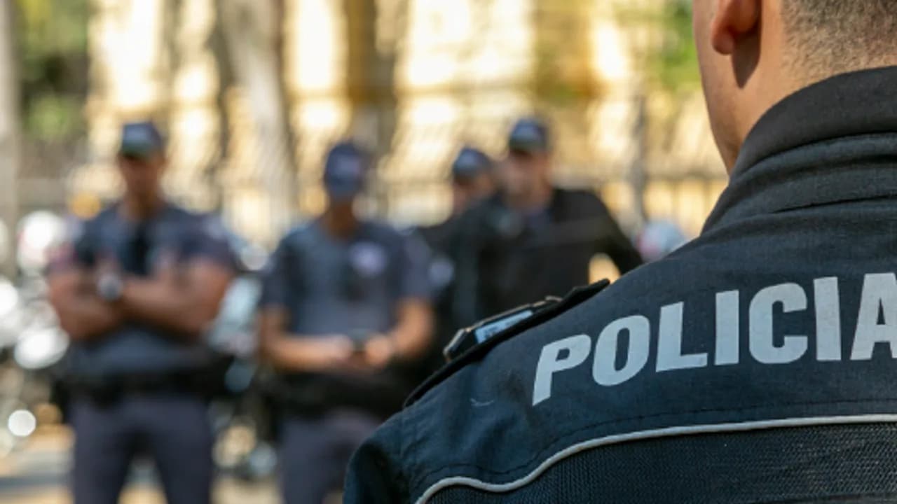 Foto de policial brasileiro em serviço com equipe ao fundo em espaço público
